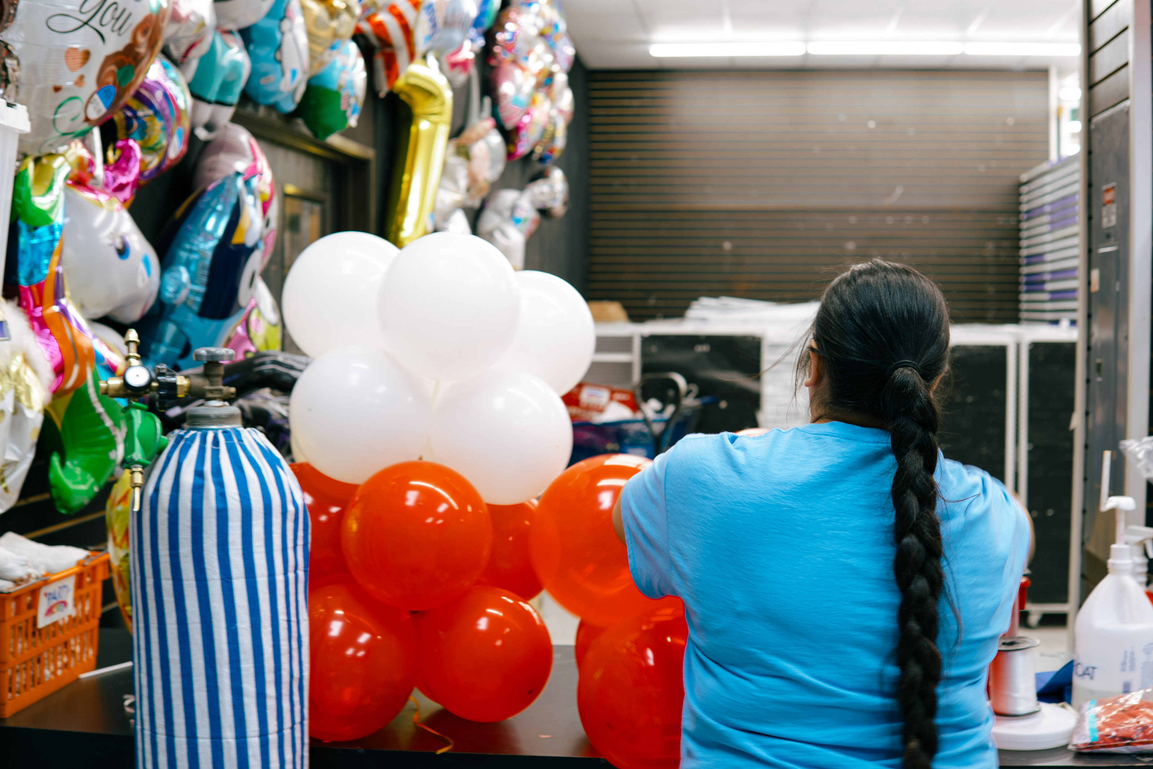PartyWorks staff inflating helium balloon arrangement at balloon bar